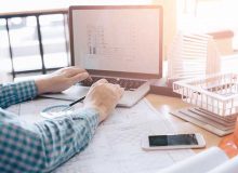 Property manager looking at CAD drawings on laptop.